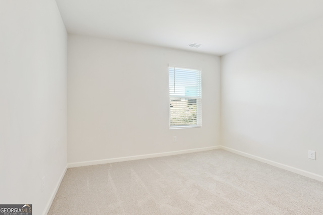 spare room featuring light colored carpet