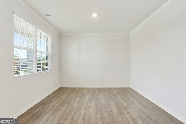 unfurnished room with ornamental molding and hardwood / wood-style floors