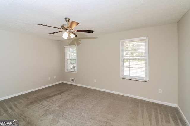 carpeted spare room featuring a textured ceiling and ceiling fan