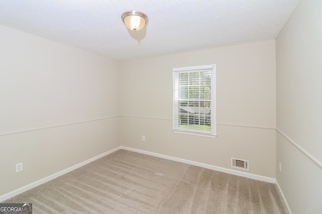 unfurnished room featuring carpet and a textured ceiling