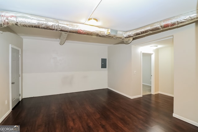 unfurnished room with electric panel and dark wood-type flooring