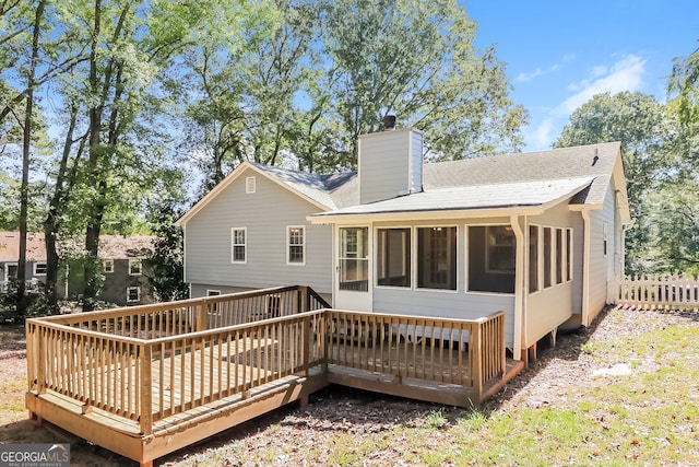 rear view of house featuring a sunroom and a deck