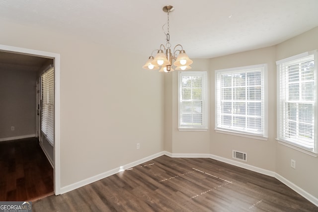 unfurnished dining area with a notable chandelier and dark hardwood / wood-style flooring