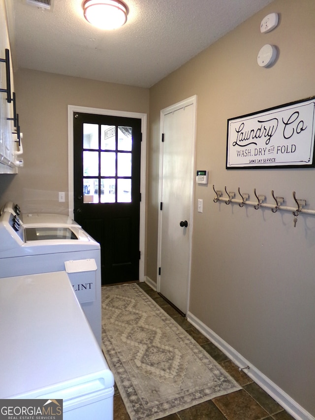 clothes washing area with a textured ceiling and separate washer and dryer