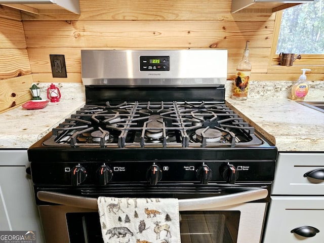 room details with stainless steel gas range oven and light stone counters