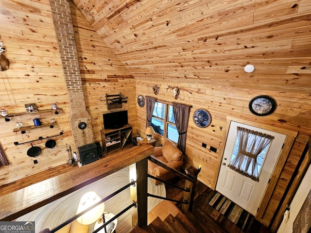 entryway featuring hardwood / wood-style floors, wood walls, and vaulted ceiling