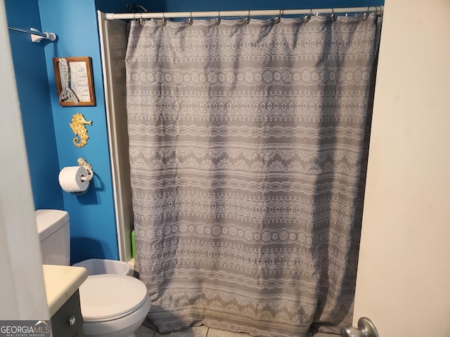 bathroom featuring a shower with shower curtain, vanity, tile patterned flooring, and toilet