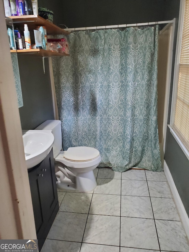 bathroom with tile patterned flooring, vanity, and toilet