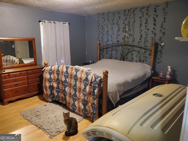 bedroom with wood-type flooring and a textured ceiling