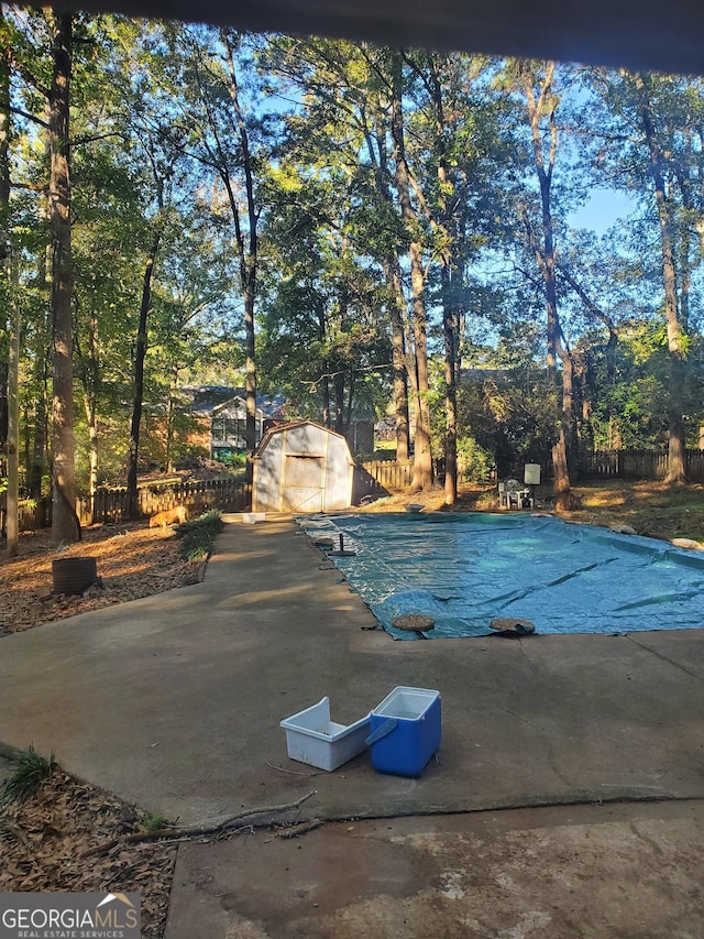 view of swimming pool featuring a storage shed