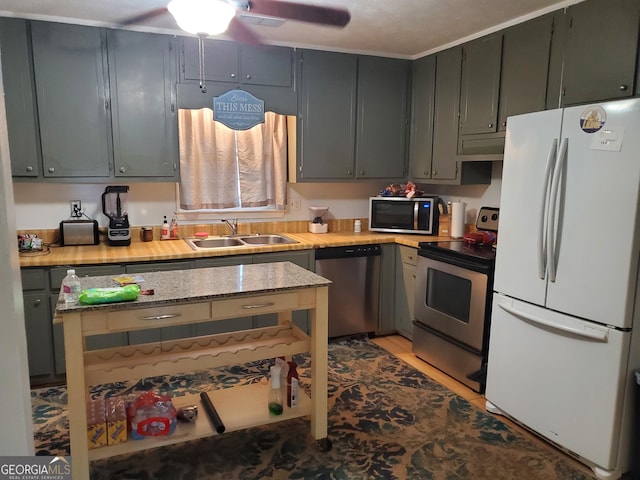 kitchen featuring exhaust hood, ceiling fan, sink, and stainless steel appliances