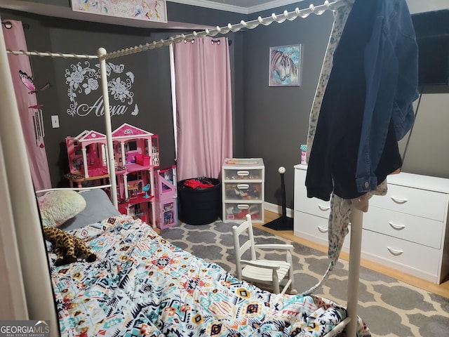 bedroom featuring crown molding and light hardwood / wood-style flooring