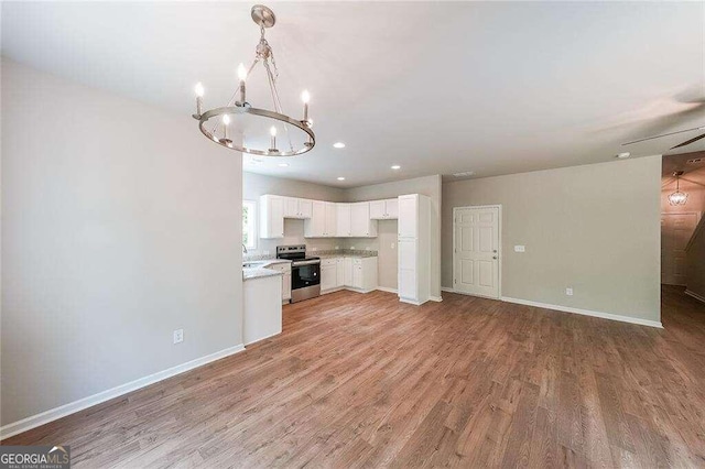 kitchen featuring hanging light fixtures, white cabinetry, stainless steel electric range oven, light wood-type flooring, and sink