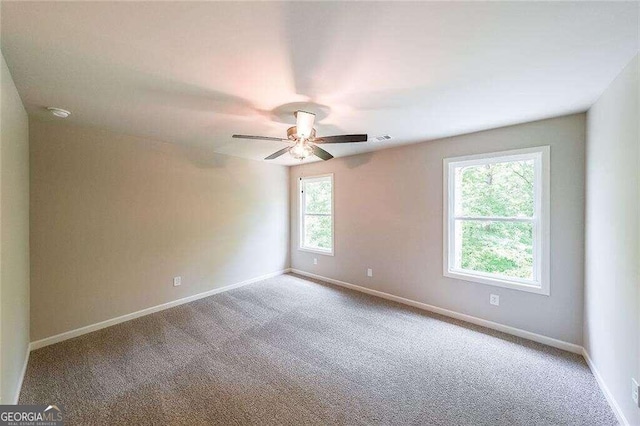 empty room featuring ceiling fan, a healthy amount of sunlight, and carpet floors