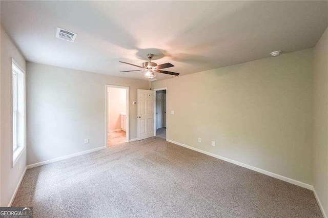 unfurnished bedroom with multiple windows, carpet floors, and ceiling fan