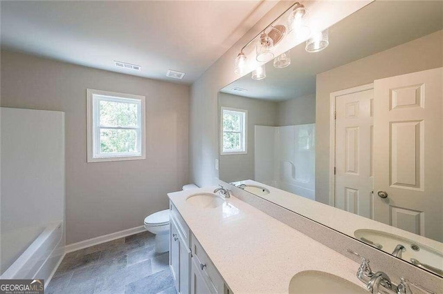 bathroom with vanity, toilet, and plenty of natural light