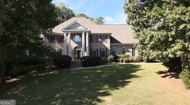 greek revival house featuring a front yard