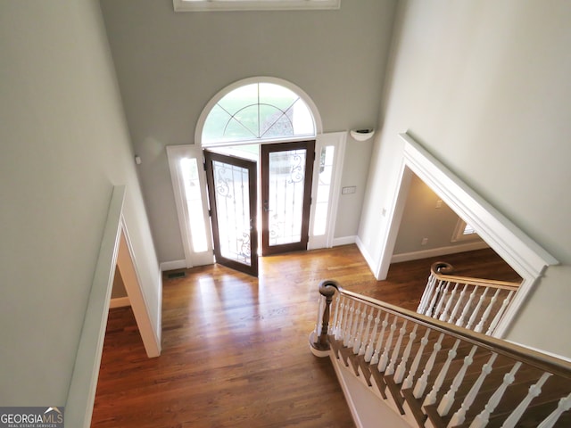 entrance foyer featuring a towering ceiling and dark hardwood / wood-style flooring