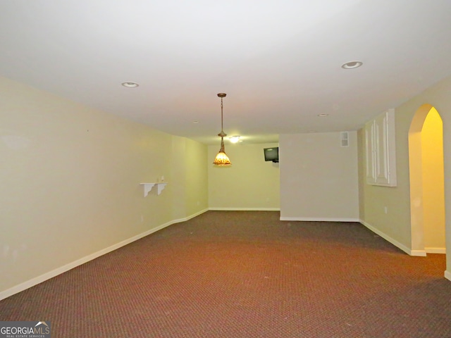 spare room with dark carpet