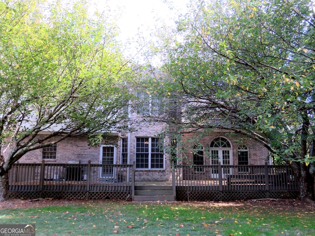 back of house featuring a deck and a lawn