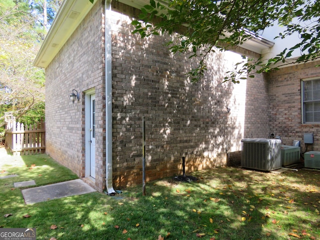 view of home's exterior with central AC and a yard