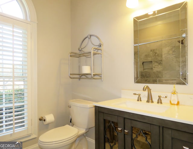 bathroom featuring vanity, toilet, and a shower