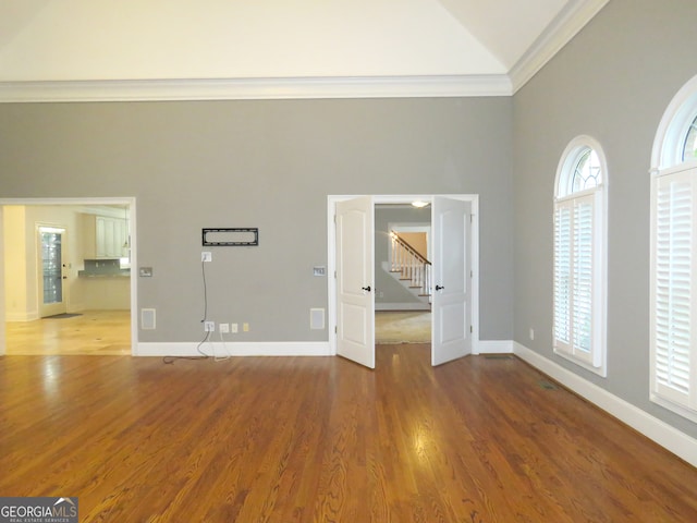 interior space with crown molding, high vaulted ceiling, and hardwood / wood-style floors