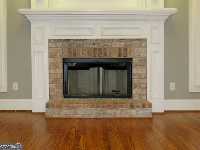 room details featuring hardwood / wood-style floors and a brick fireplace