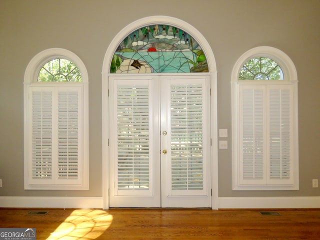 doorway with hardwood / wood-style floors and plenty of natural light