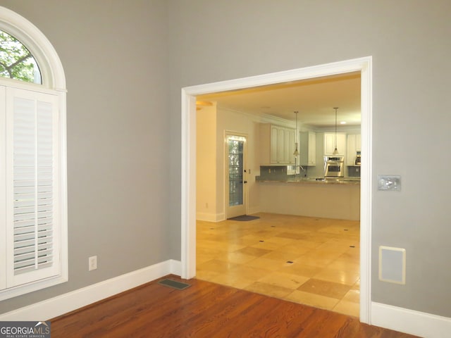 foyer featuring crown molding, sink, and light wood-type flooring