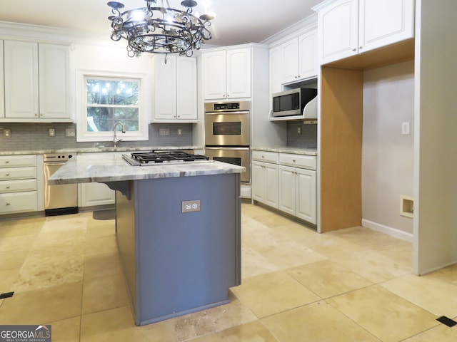 kitchen featuring white cabinets, tasteful backsplash, decorative light fixtures, and a kitchen island