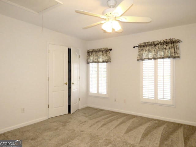 carpeted spare room featuring ceiling fan