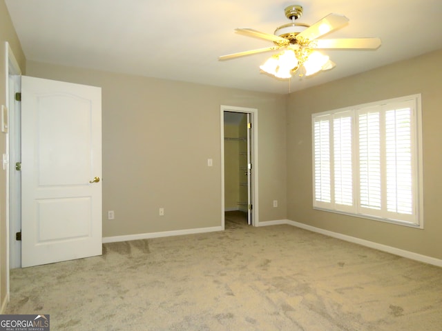 spare room featuring ceiling fan and light colored carpet