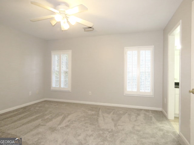 carpeted spare room featuring ceiling fan