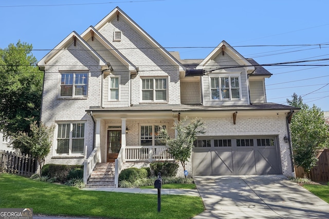 view of front of property featuring a front yard, a garage, and covered porch