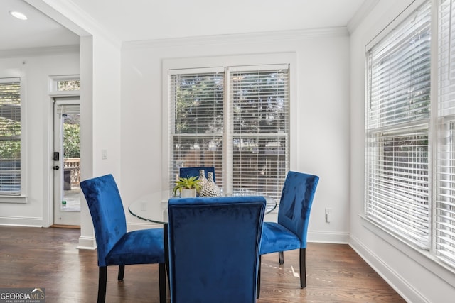 dining room featuring crown molding, a healthy amount of sunlight, and dark hardwood / wood-style flooring