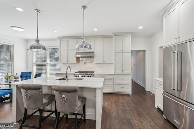 kitchen with ornamental molding, sink, pendant lighting, appliances with stainless steel finishes, and dark hardwood / wood-style flooring