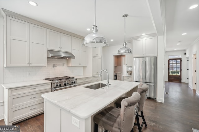 kitchen with hanging light fixtures, a kitchen island with sink, dark wood-type flooring, high quality appliances, and sink