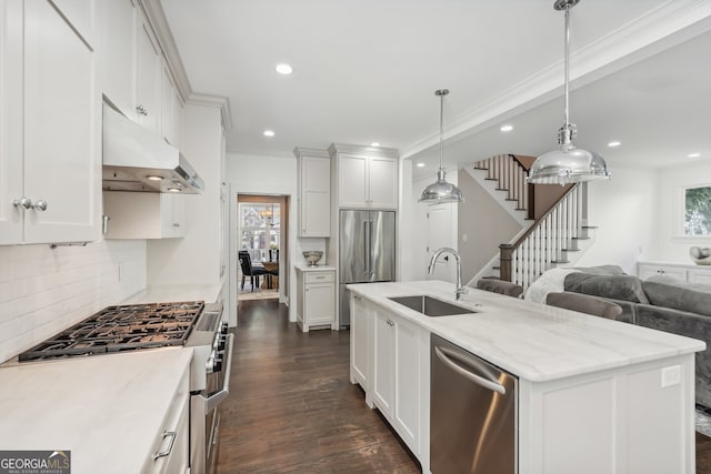 kitchen featuring an island with sink, white cabinetry, dark hardwood / wood-style floors, high quality appliances, and sink