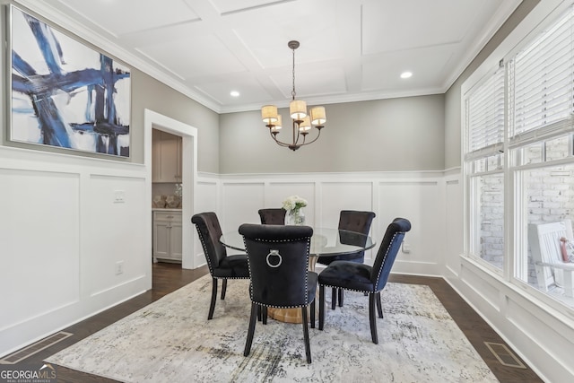 dining room with dark wood-type flooring, crown molding, and an inviting chandelier