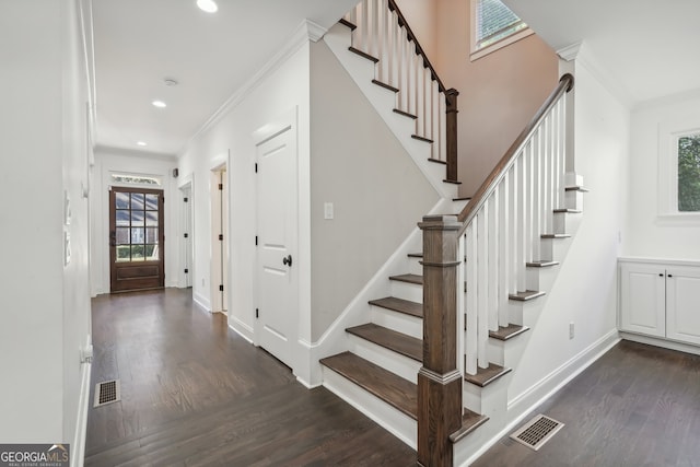 stairs featuring ornamental molding, hardwood / wood-style floors, and a healthy amount of sunlight