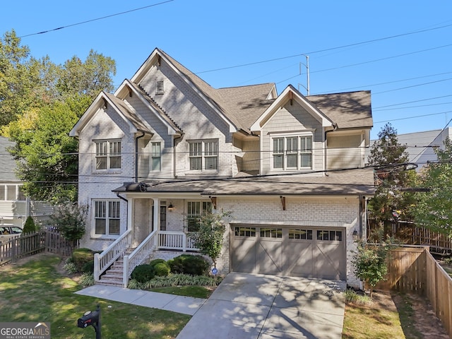 view of front of property with covered porch, a garage, and a front lawn