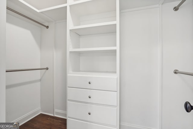 walk in closet with dark hardwood / wood-style flooring