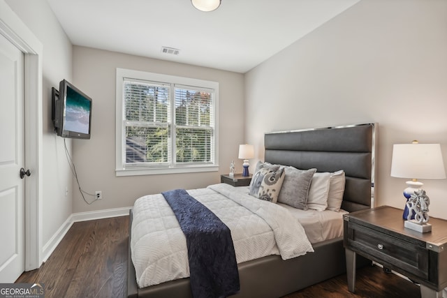 bedroom with dark hardwood / wood-style flooring