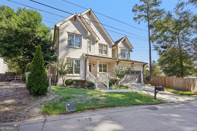 front facade featuring a front yard, covered porch, and a garage