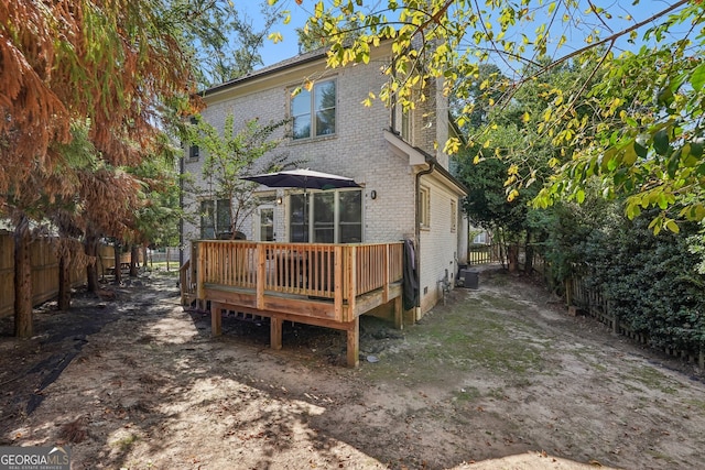 rear view of property featuring central AC and a wooden deck