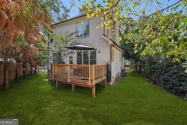 rear view of house with a yard, a deck, and central AC unit