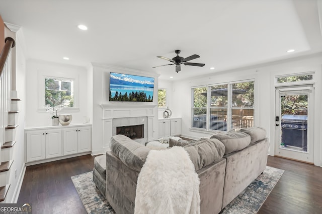 living room with ceiling fan, a wealth of natural light, and dark hardwood / wood-style floors