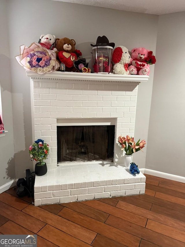 details with a textured ceiling, a fireplace, and hardwood / wood-style floors