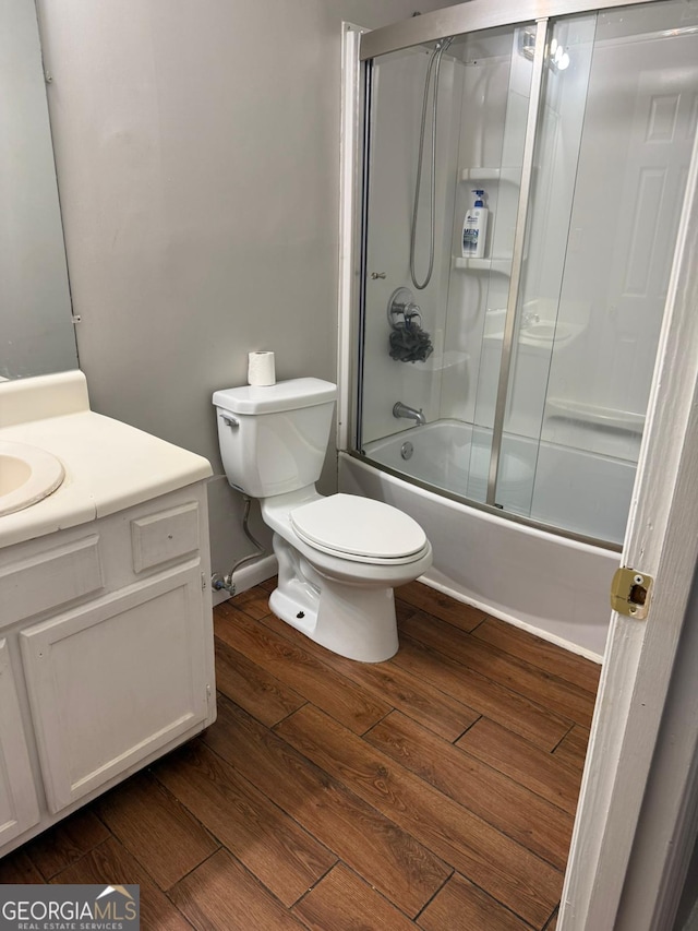 full bathroom with vanity, hardwood / wood-style floors, toilet, and enclosed tub / shower combo